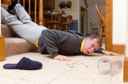 An adult male falls at the foot of a staircase.